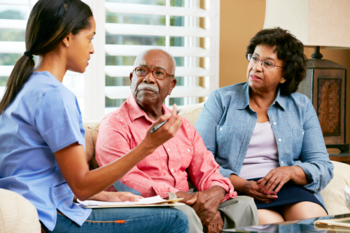 caregiver discussing care plan to an elderly couple